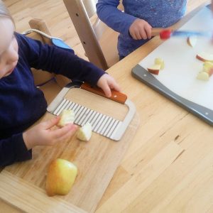 Kleinkind schneidet Erdäpfel