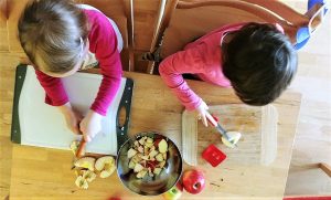 Kinder helfen beim Äpfel schneiden